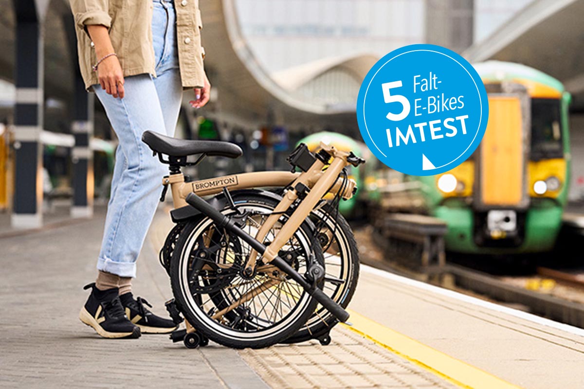 Person mit Falt-E-Bike an einem Bahnsteig.