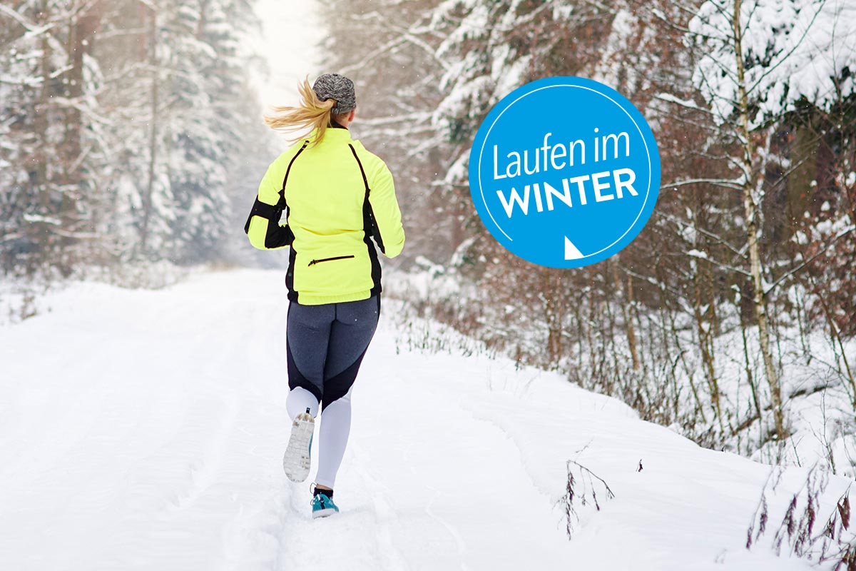 Person läuft in einem Wald durch Schnee.