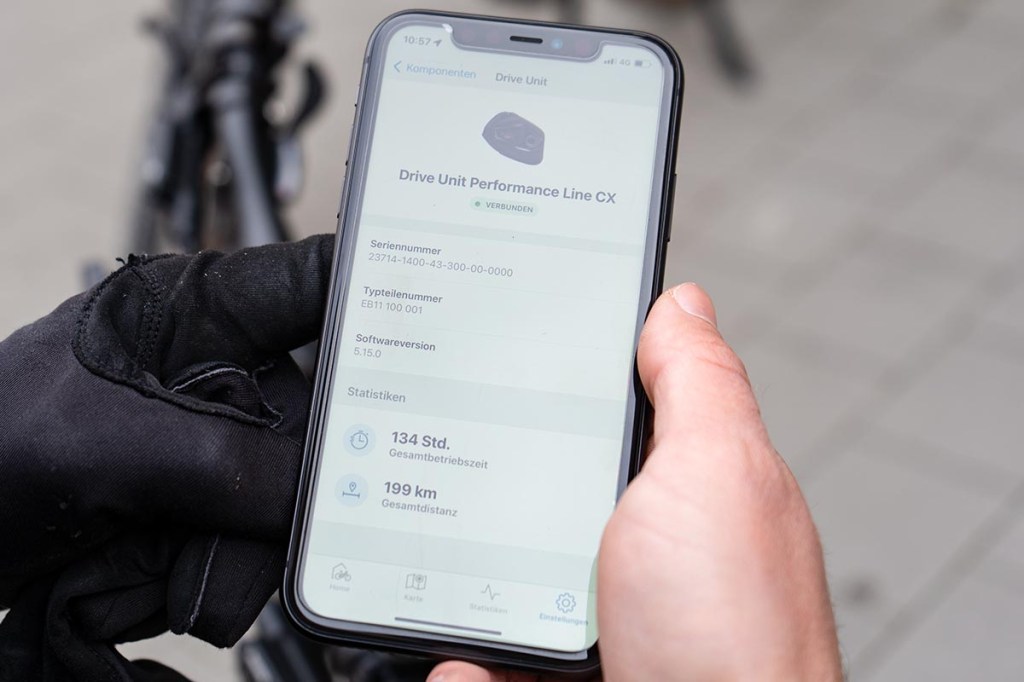 Nahaufnahme: Hand hält Smartphone fest, darauf sieht man Bosch eBike Flow App geöffnet