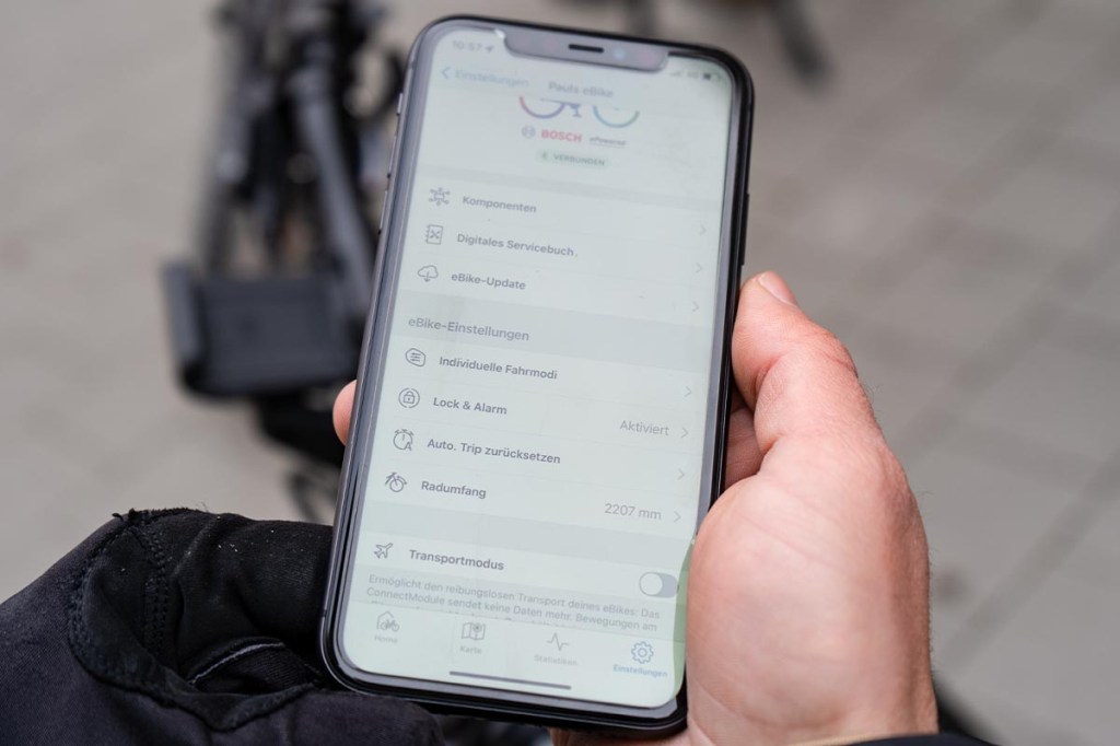 Nahaufnahme: Hand hält Smartphone fest, darauf sieht man Bosch eBike Flow App geöffnet