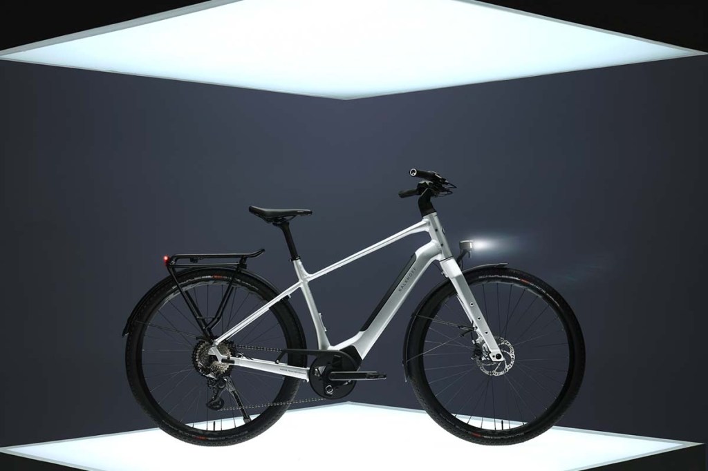 weißes, schlankes city-e-bike, welches auf einem beleuchteten podest steht