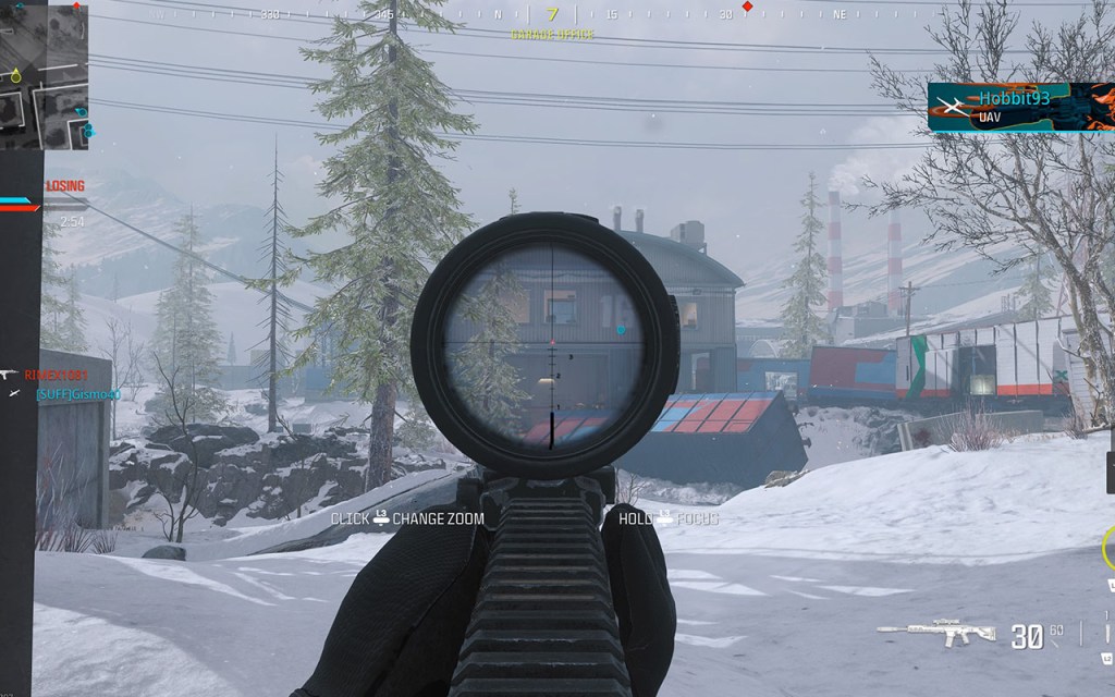 Screenshot aus dem Multiplayer von Modern Warfare 3. Der Spieler zielt durch ein Zielfernrohr auf ein entferntes Gebäude in Schneelandschaft.