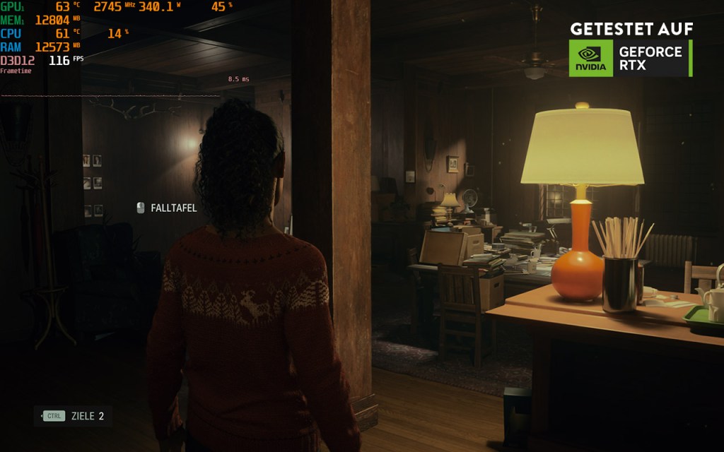 Screenshot aus Alan Wake 2. Die Spielfigur steht in einem dunklen Raum neben einer Tischlampe.