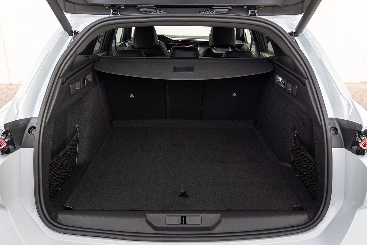 E-Auto Kombi Peugeot E-308 SW mit geöffneter Kofferraumklappe und zurückgeschobener Trenn-Abdeckung über dem Gepäckfach.