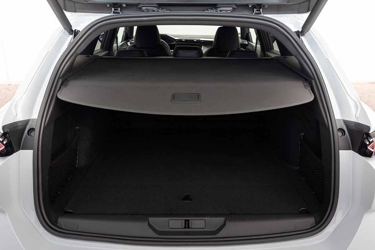 E-Auto Kombi Peugeot E-308 SW mit geöffneter Kofferraumklappe und vorgezogener Trenn-Abdeckung über dem Gepäckfach.
