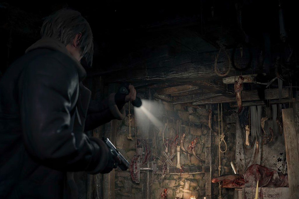 Screenshot von Resident Evil 4 für iPhone: Spielfigur Leon erkundet im Schein der Taschenlampe eine blutverschmierte Werkstatt.