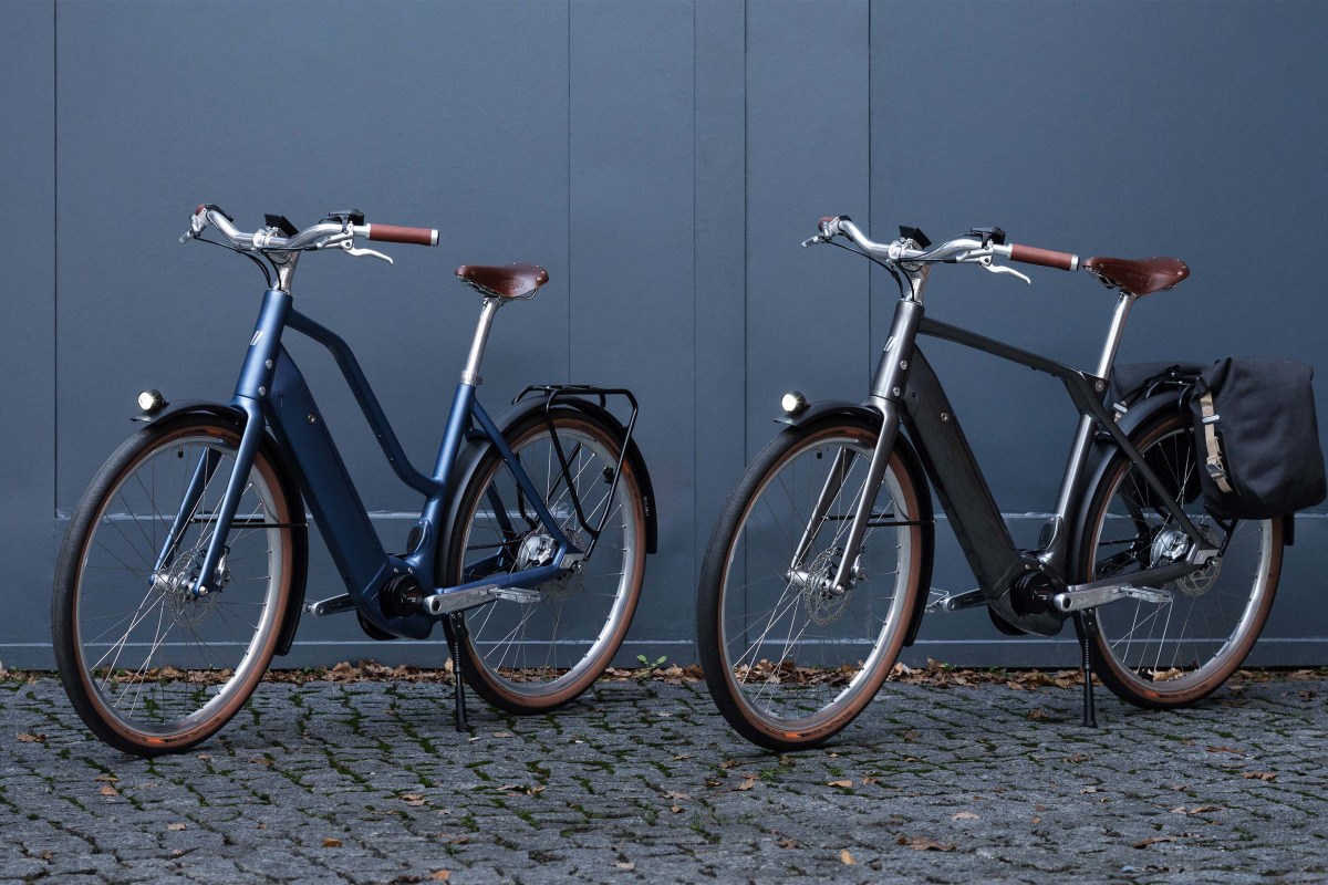 zwei E-Bikes stehen nebeneinander vor einem blauen Tor