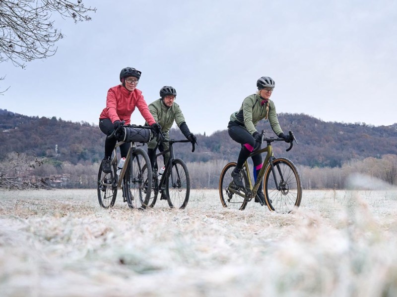Drei Radfahrer in einer winterlichen Landschaft
