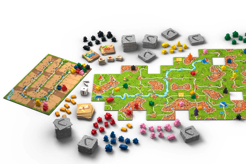 Das Brettspiel Carcassonne, einige Spielmaterialien vor weißem Hintergrund.