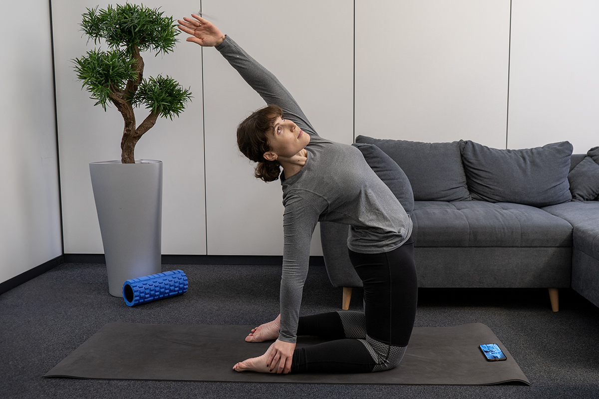 Eine Frau macht Yoga-Übungen auf dem Boden.