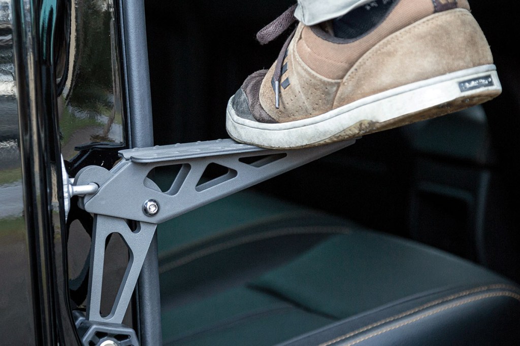Detailaufnahme: Fuß steht auf Trittstufe, die sich an einem Wagen befestigen lässt, um besser an Staugepäck auf dem Fahrzeugdach zu gelangen.