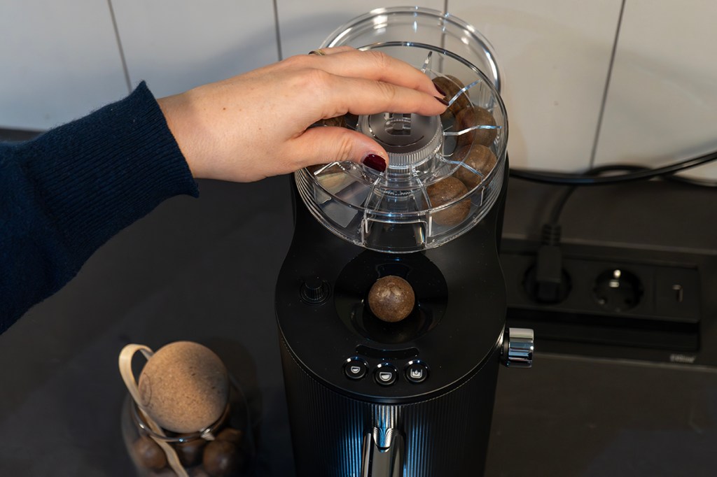 Eine Kaffeekugel wird aus dem Dispenser in die CoffeeB-Maschine gegeben.