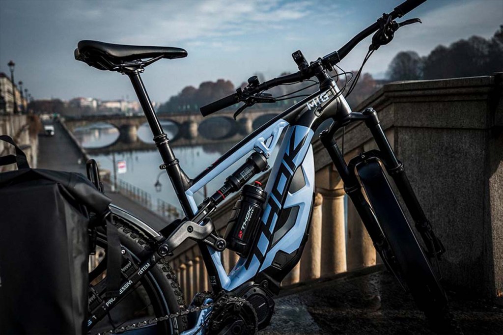 E-Bike auf einer Brücke stehend, Fluss im Hintergrund, man sieht den Rahmen des Rads