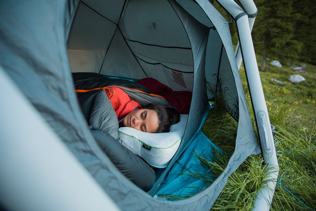 Frau schlafend auf Seitenschläferkissen in einem Zelt.