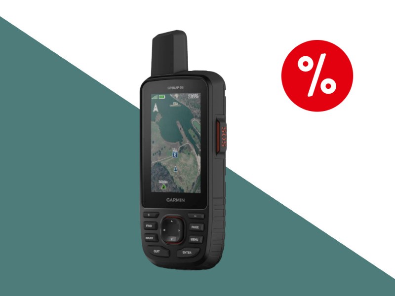 Schwarzes längliches Garmin-GPS mit kurzer dicker Antenne oben links schräg von vorne zeigt blau grüne Karte auf dunkelgrün weißem Hintergrund mit rotem Prozentbutton oben rechts