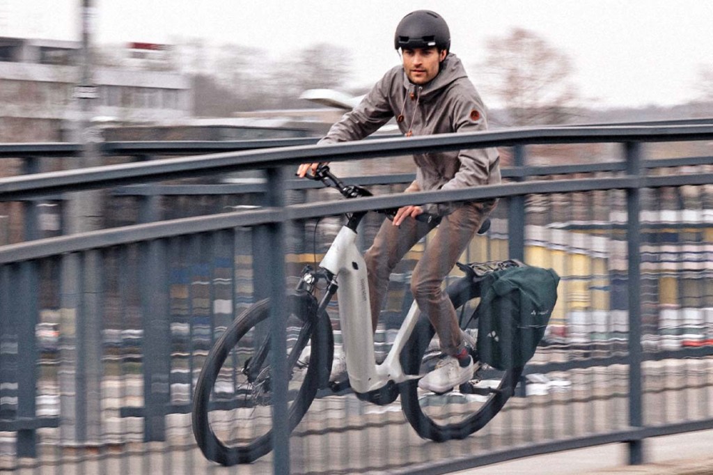 Man fährt mit einem E-bike über eine Brücke