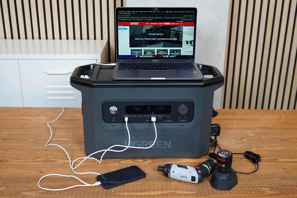 Ein Laptop, ein Smartphone, ein Akkuschrauber und ein extra Akku sind an der Ugreen PowerRoam 2200 angeschlossen.