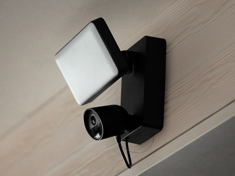 Die Flutlichtkamera Philips Hue Secure, an einer Wand hängend.