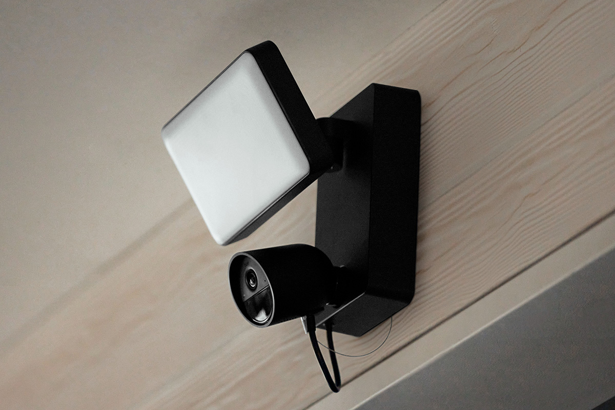 Die Flutlichtkamera Philips Hue Secure, an einer Wand hängend.