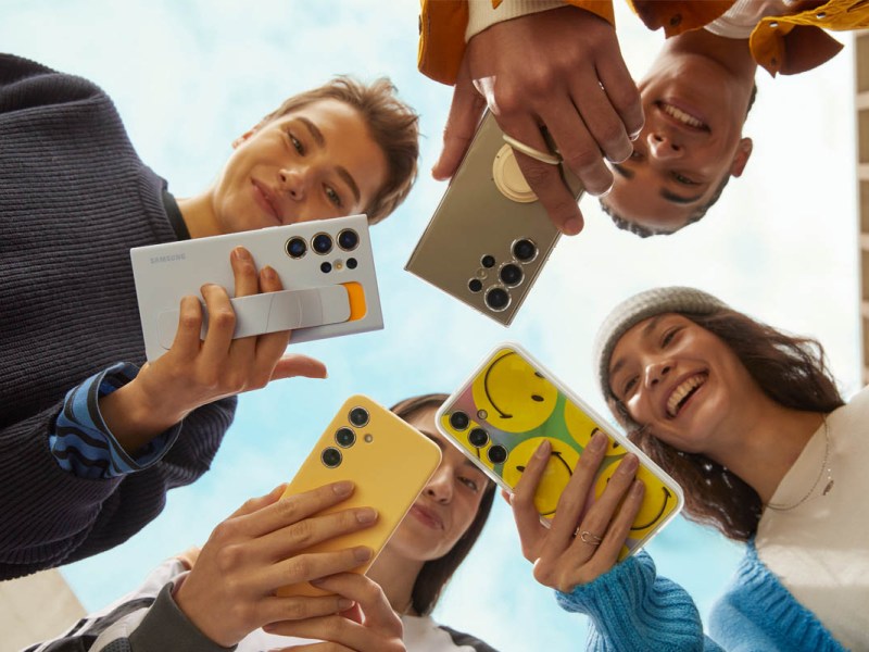 Eine Gruppe Jugendlicher schaut auf ihre S24-Smartphones
