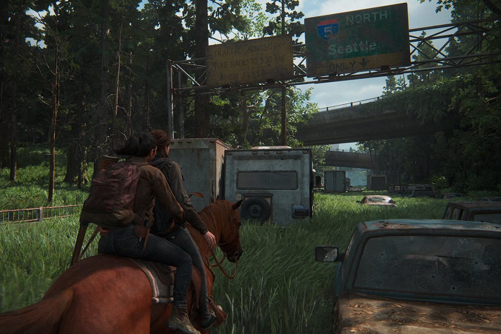 Ein Screenshot aus dem Videospiel The Last of Us Part 2 Remastered für PS5. Zu sehen sind zwei Frauen, die auf einem Pferde über eine überwuchterte Autobahn reiten.