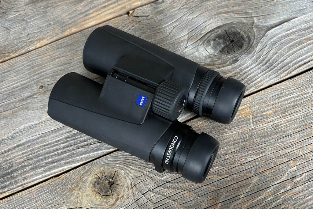 Das Fernglas Zeiss Conquest HD 10x42 von oben, auf einem Holzuntergrund.