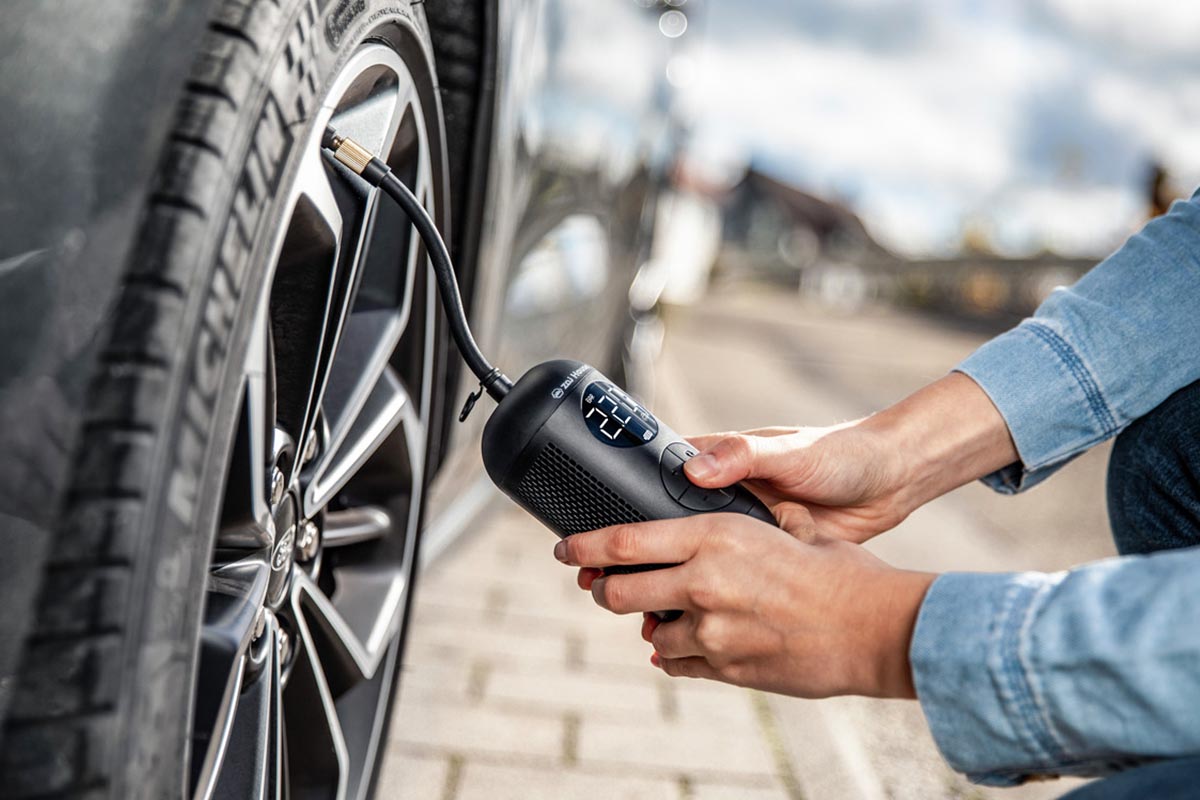 Elektrische Luftpumpe, die einen Autoreifen aufpumpt.