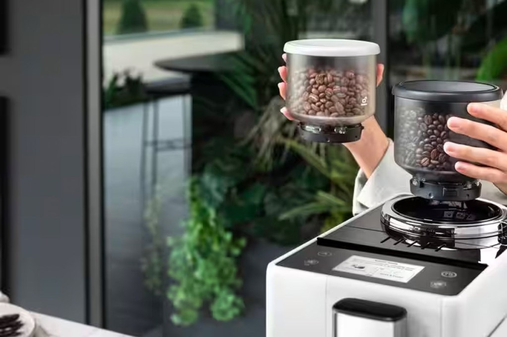 Eine Person wechselt den Kaffeebohnen-Behälter eines Rivelia Kaffeevollautomaten.