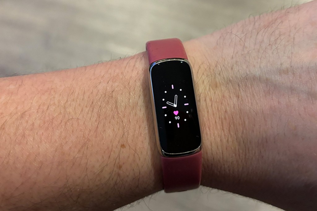 Foto einer Männerhand, mit dem Fitness-Tracker Fitbit Luxe am Handgelenk. Zu sehen ist ein Uhren-Ziffernblatt.