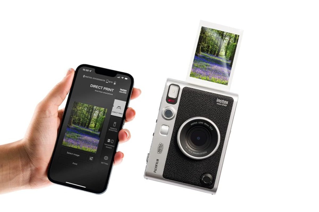 Hand hält links Smartphone rein, das Foto anzeigt, daneben hochkant Sofortbildkamera Mini Evo in schwarz silber mit ausgedrucktem Foto oben auf weißem Hintergrund