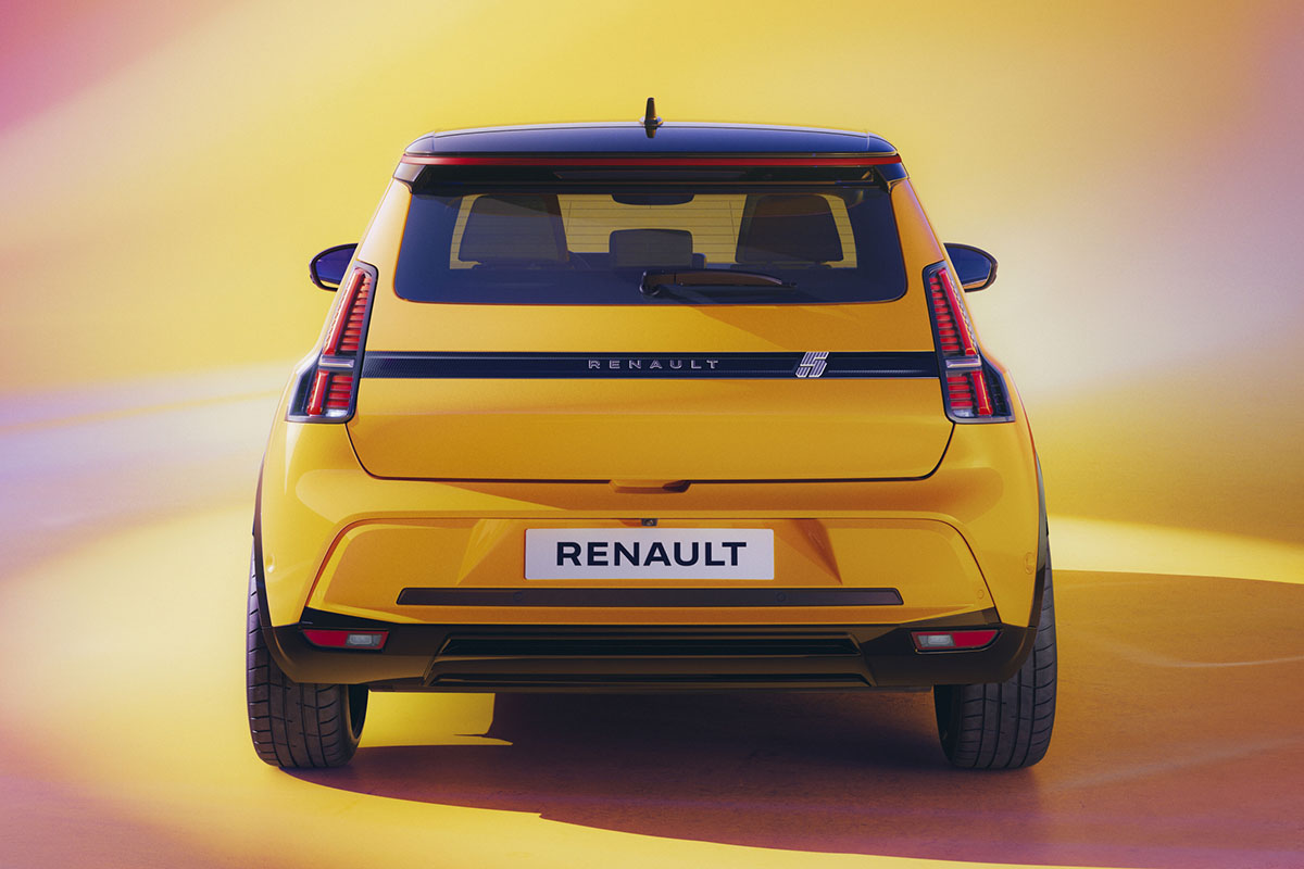 Gelber Renault 5 E-Tech Electric steht in Studiokulisse von hinten aus gesehen.
