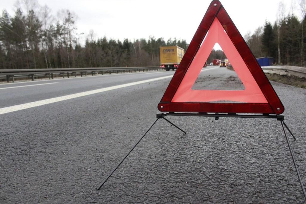 Warndreieck auf grauem Asphalt von Autobahn aufgestellt aus Froschperspektive