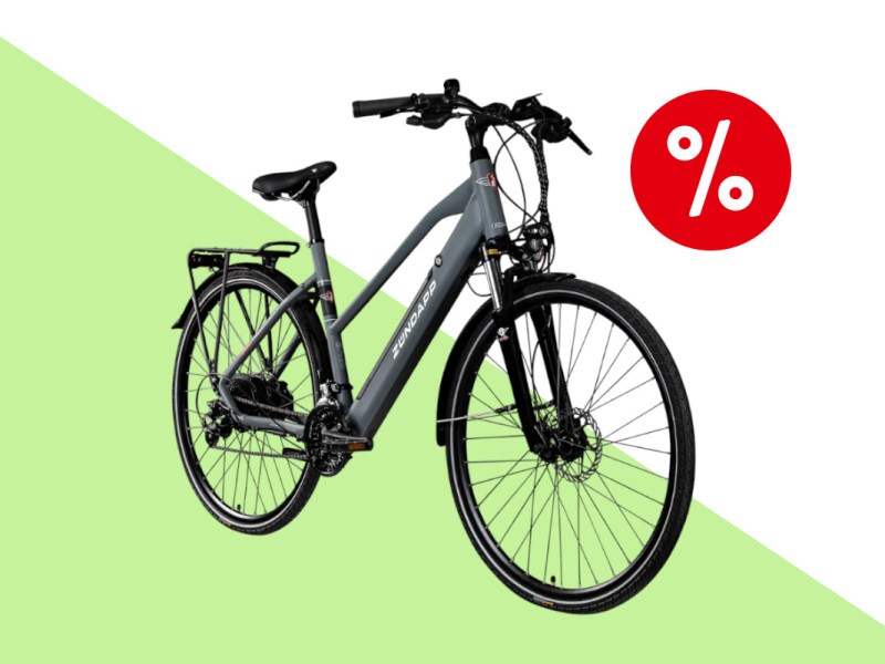 Graues E-Bike von Zündapp schräg von vorne auf hellgrünem weißem Hintergrund mit rotem Prozentbutton oben rechts