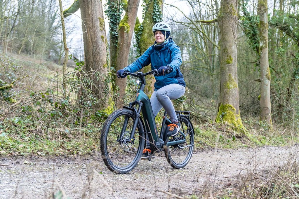 Frau fährt mit einem E-Bike durch den Wald