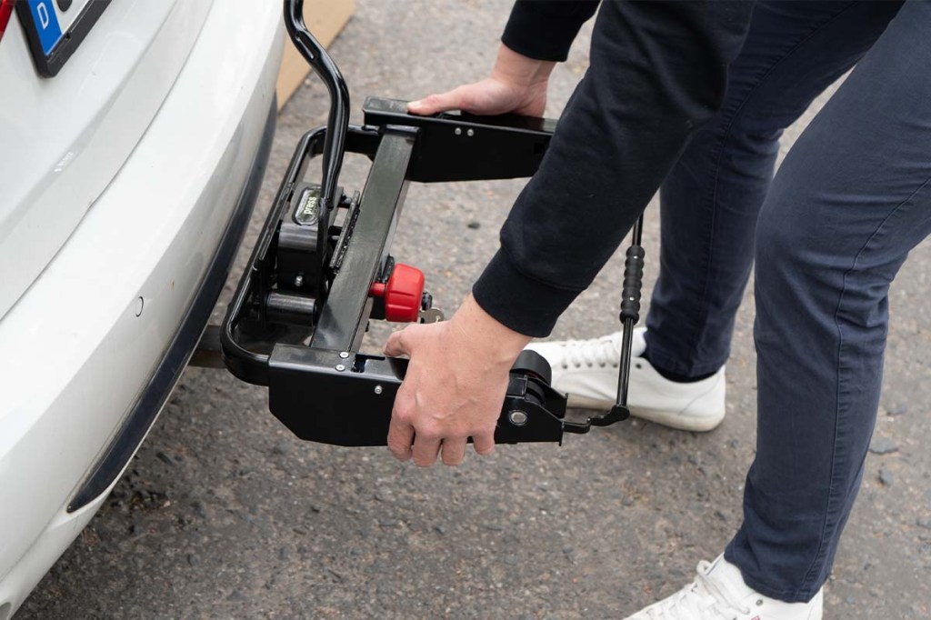 Anschnitt HEck eines Autos, Person befestigt Basisträger für Box