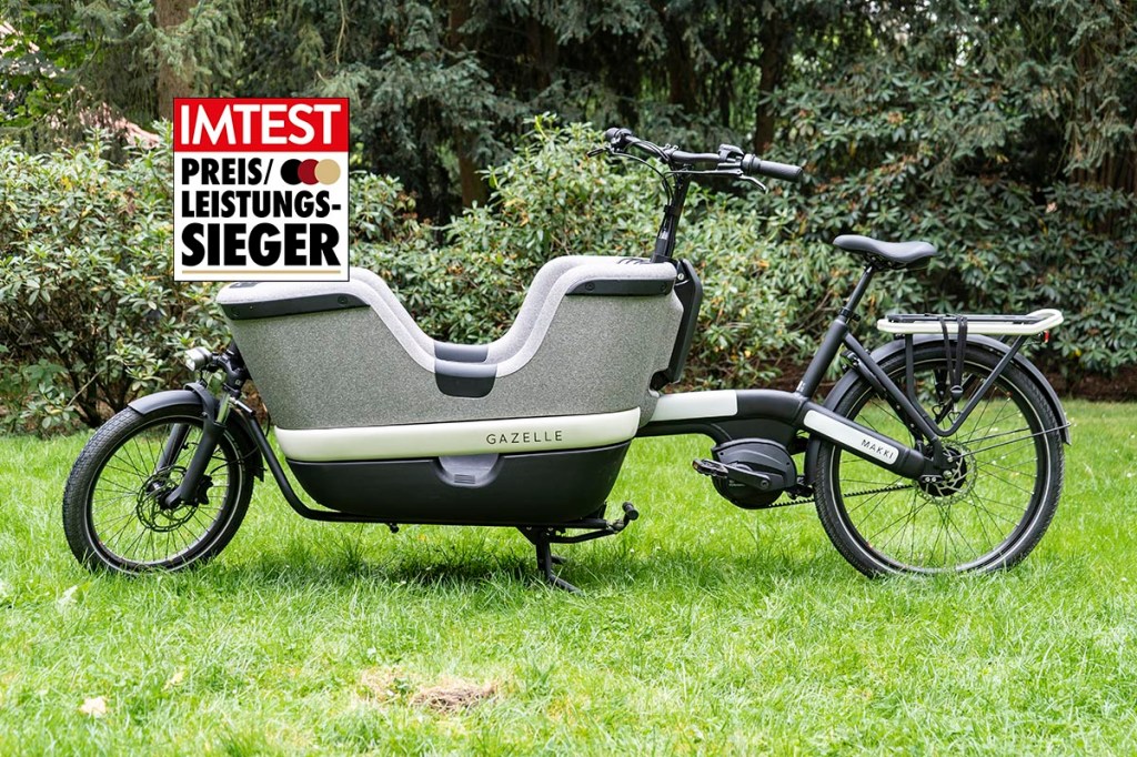 Cargo-E-Bike auf einer Wiese stehend mit Preis leistung-Siegel