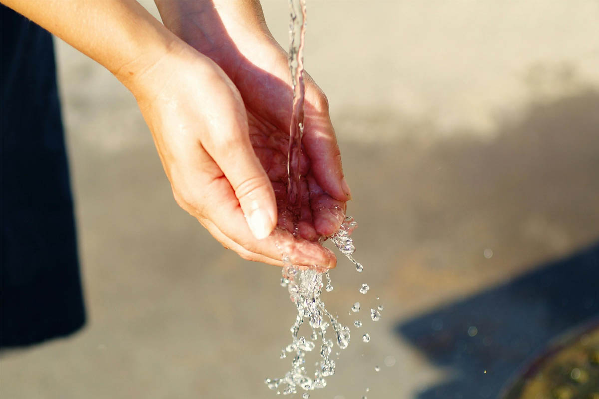 Zwei Hände fangen Wasser auf.