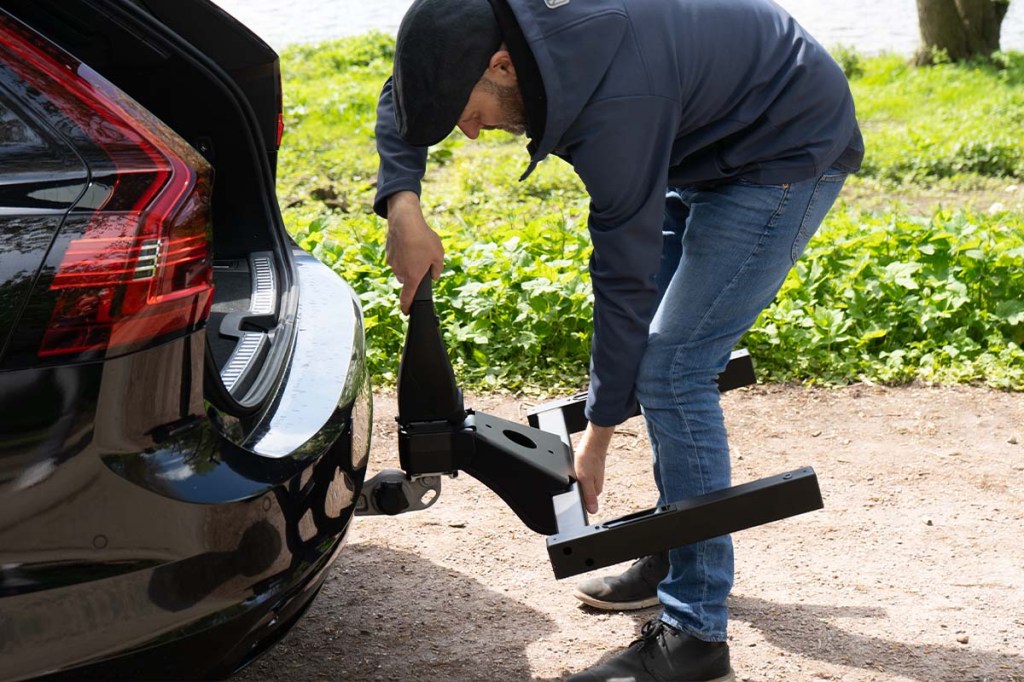 Anschnitt HEck eines Autos, Person befestigt Basisträger für Box
