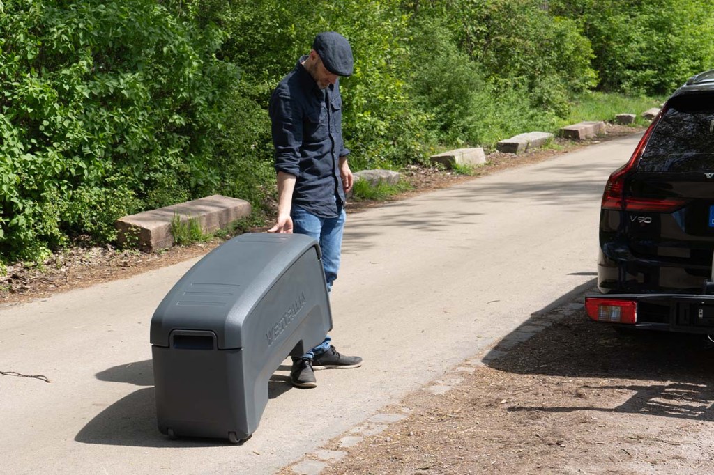Mann zieht Transportbox