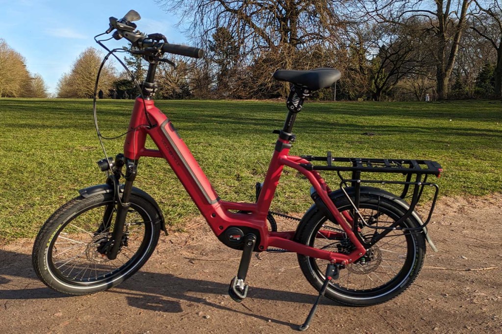 Totale rotes E-bike in einem Park stehend