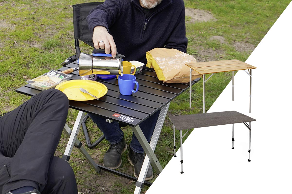 Personen am gedeckten Campingtisch auf einer Wiese.