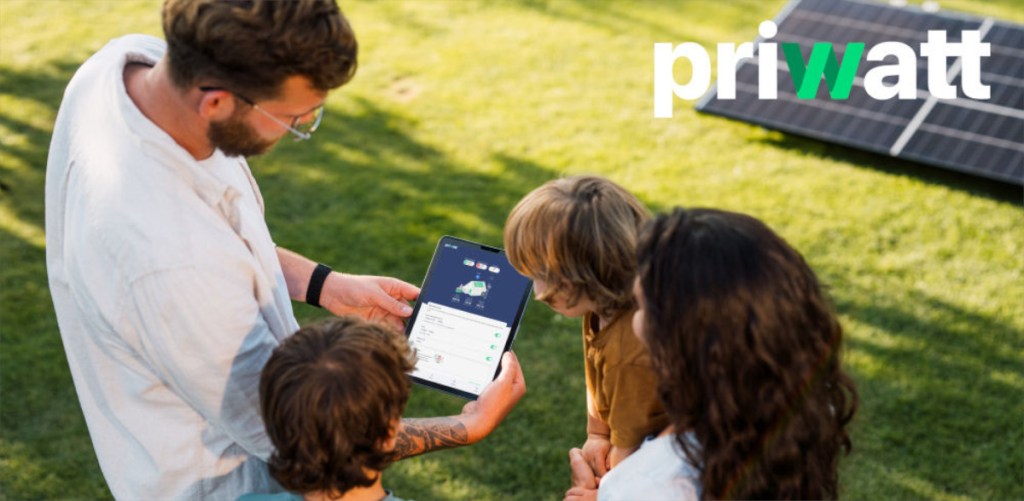 Ein Mann zeigt zwei Kindern und einer Frau auf einem Tablet die Priwatt-App.