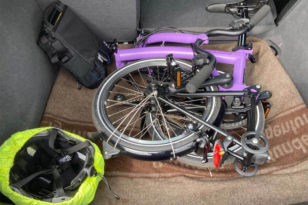 Zusammengeklapptes Faltrad im Kofferraum eines Autos liegend