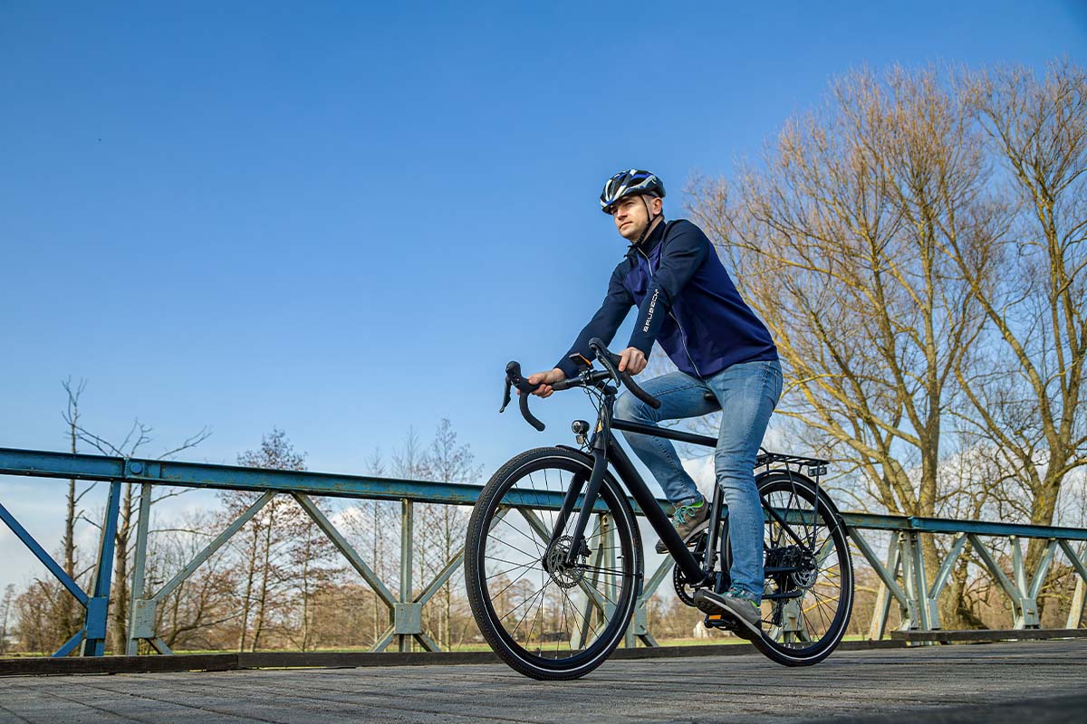 Mann fährt mit einem E-Bike über eine Brücke