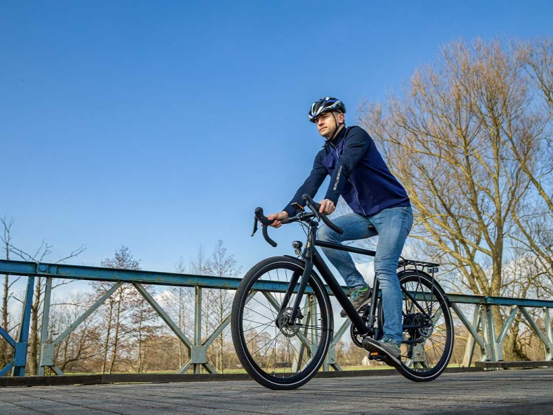 Mann fährt mit einem E-Bike über eine Brücke