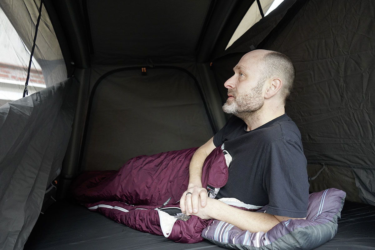 Mann liegt mit Schlafsack im Dachzelt TRT 140 Air von Dometic.