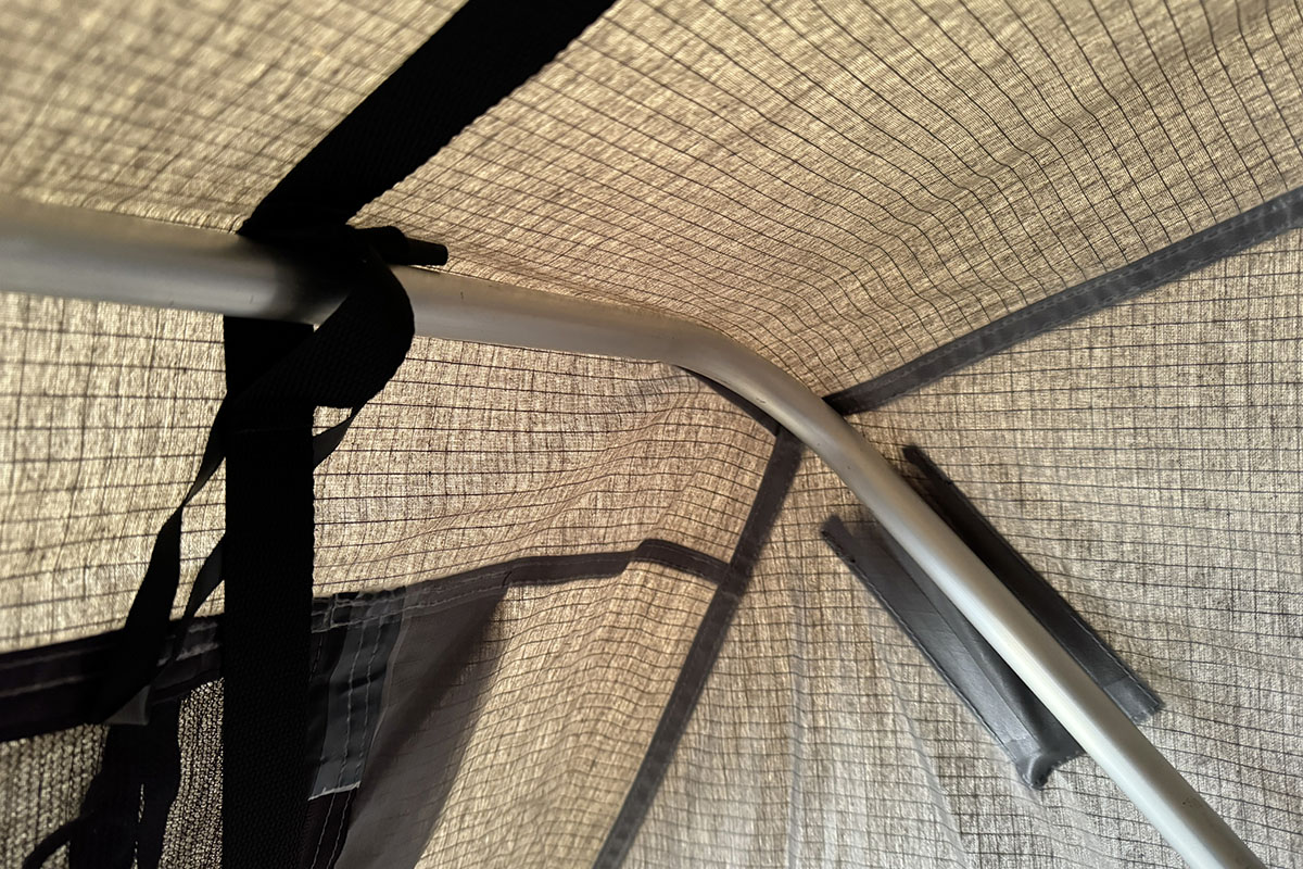 Detailansicht im Inneren eines Dachzelts, die zeigt, wie das Gestänge des Zelts an den Wänden befestigt ist