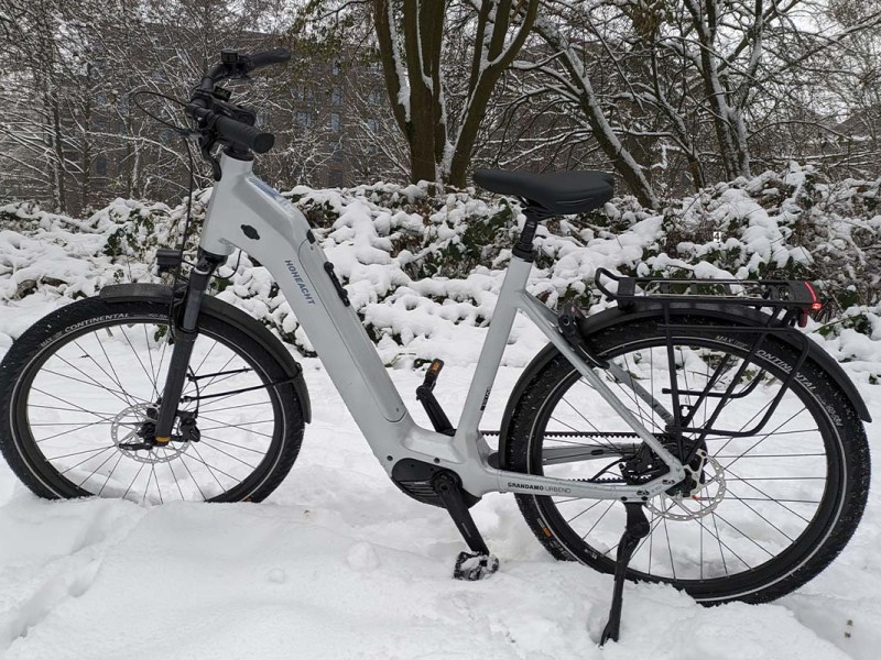 weißes City-E-Bike im Schnee stehend