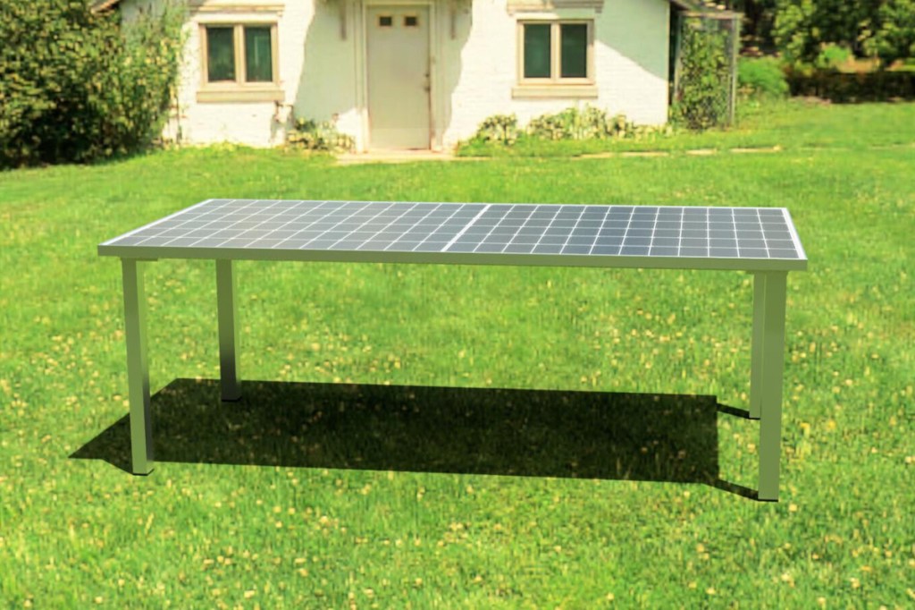 Heller Solartisch von der Seite auf grüner weitläufiger Rasenfläche, im Hintergrund weißes Häuschen