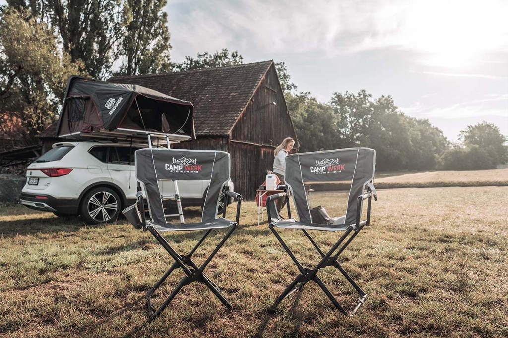 Zwei Camping-Klappstühle im Vordergrund, im Hintergrund ein Campervan